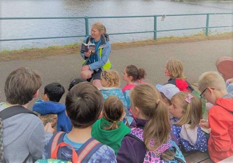 Network librarian Meg Davidson reads a story about Nessie and St Columba to children by the riverside in Inverness during a nature walk activity in collaboration with the High Life Highland countryside rangers.