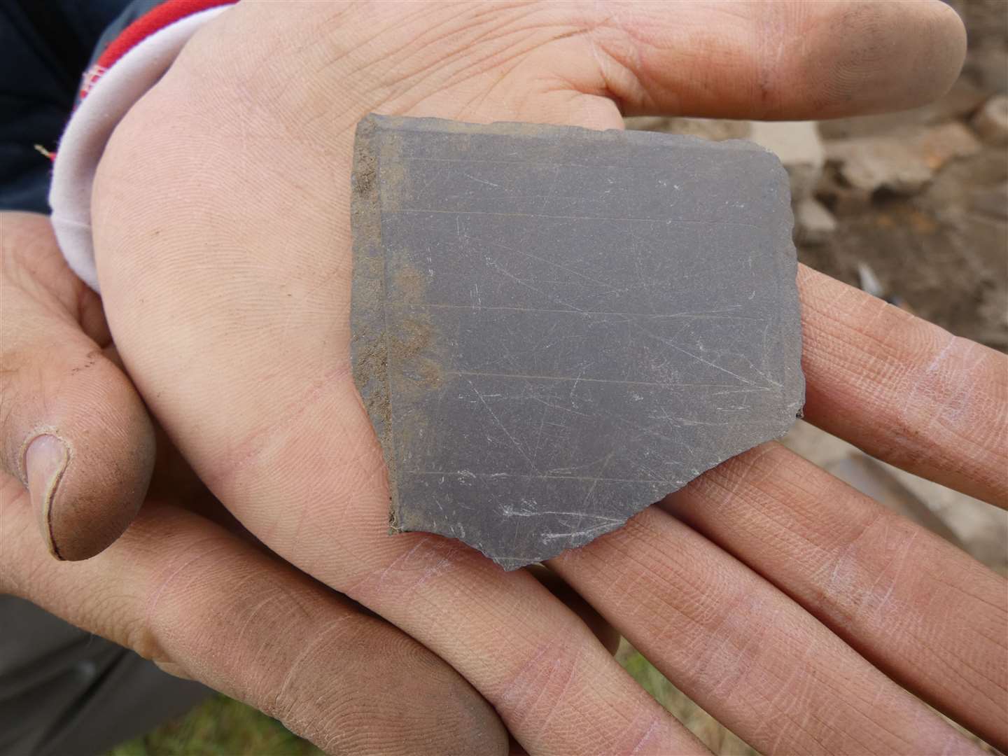 A piece of a slate board was found, with construction lines for writing.