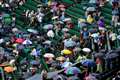 Tennis fans in macs and under umbrellas in queue for Wimbledon’s middle Sunday