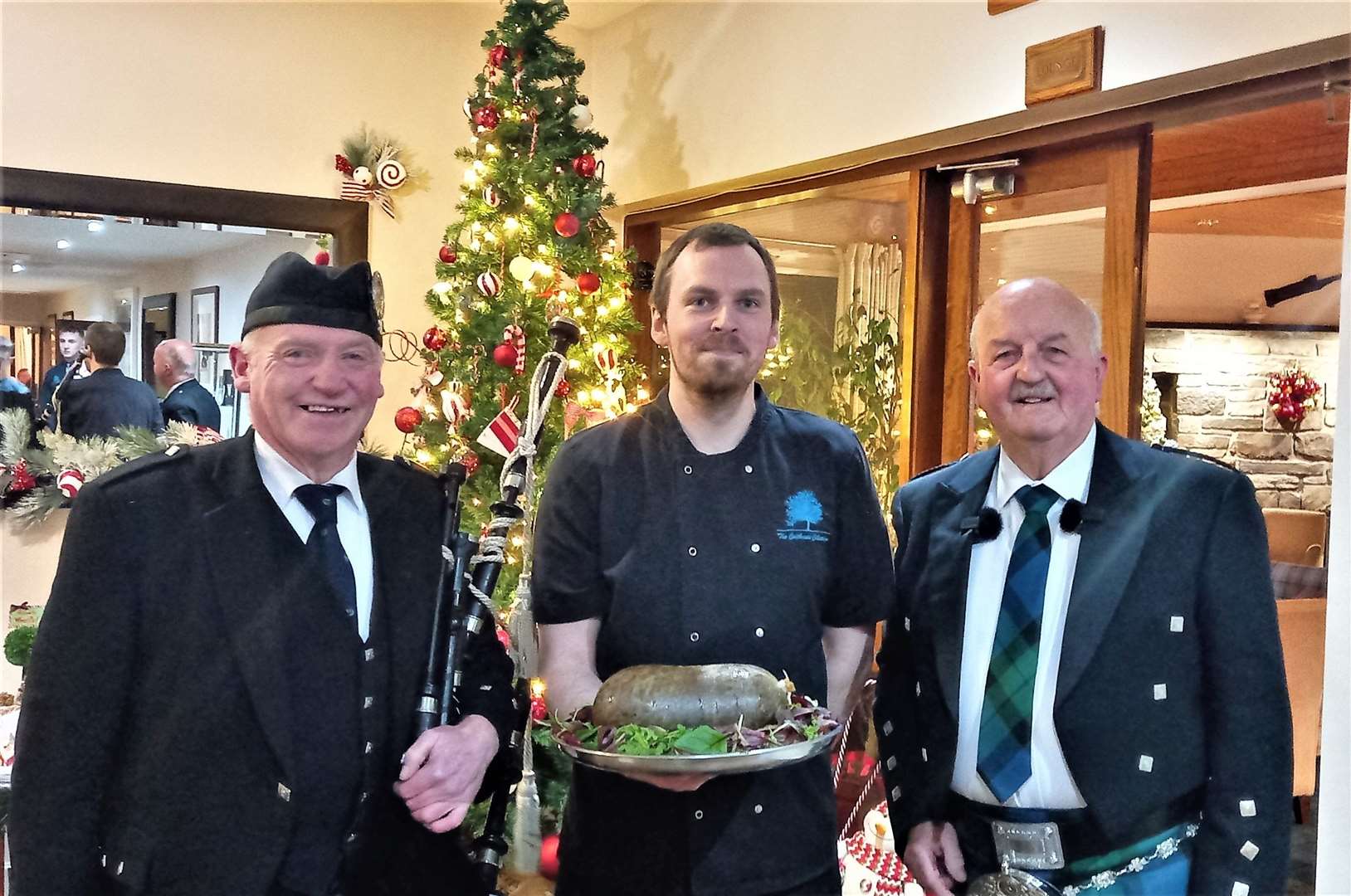 A full house at the Norseman Hotel Wick awaits the arrival of the haggis piped in by Alasdair Miller (left), carried by chef Phil Overton (centre) and addressed by Willie Mackay at right.