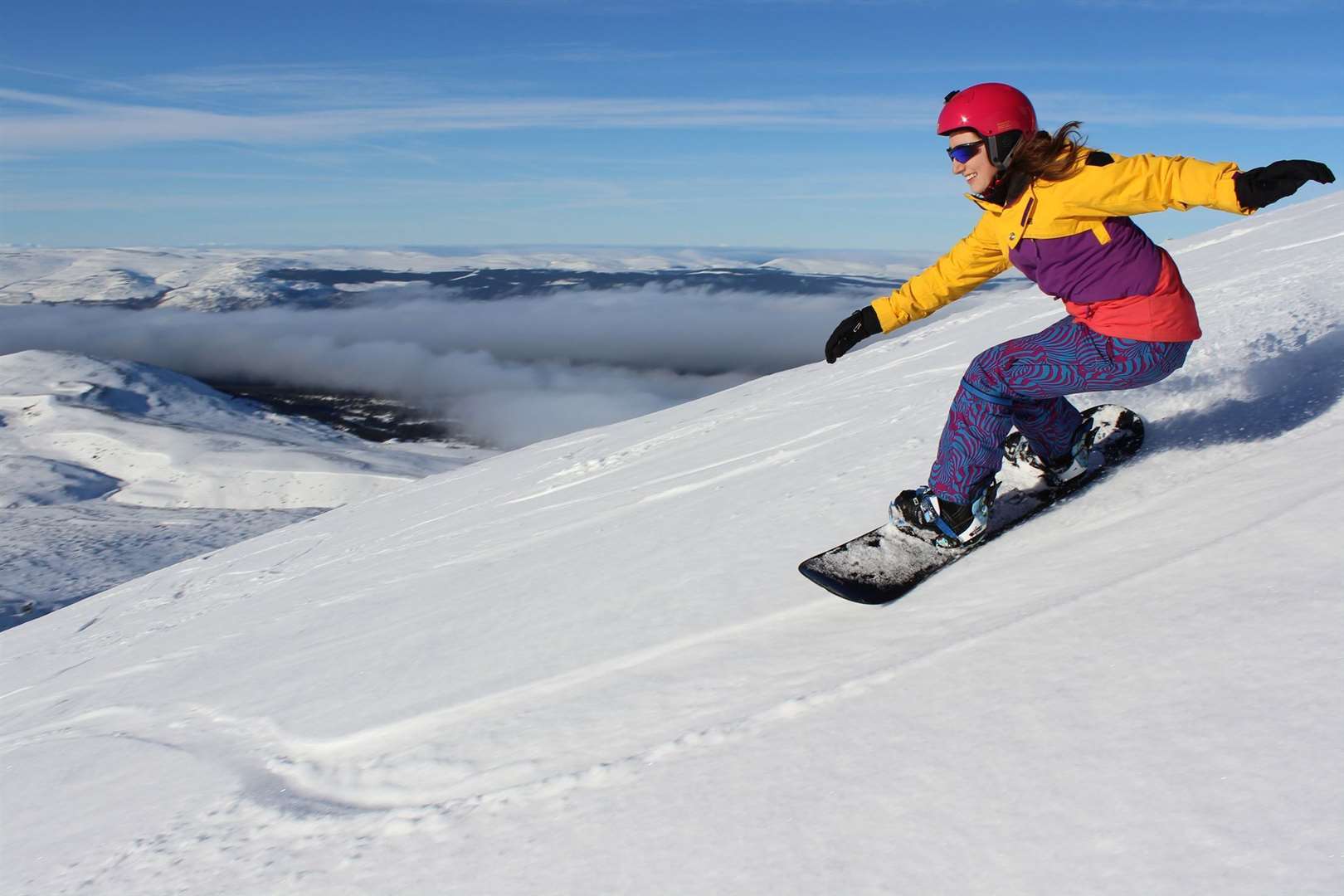A snowboarder heads off piste.