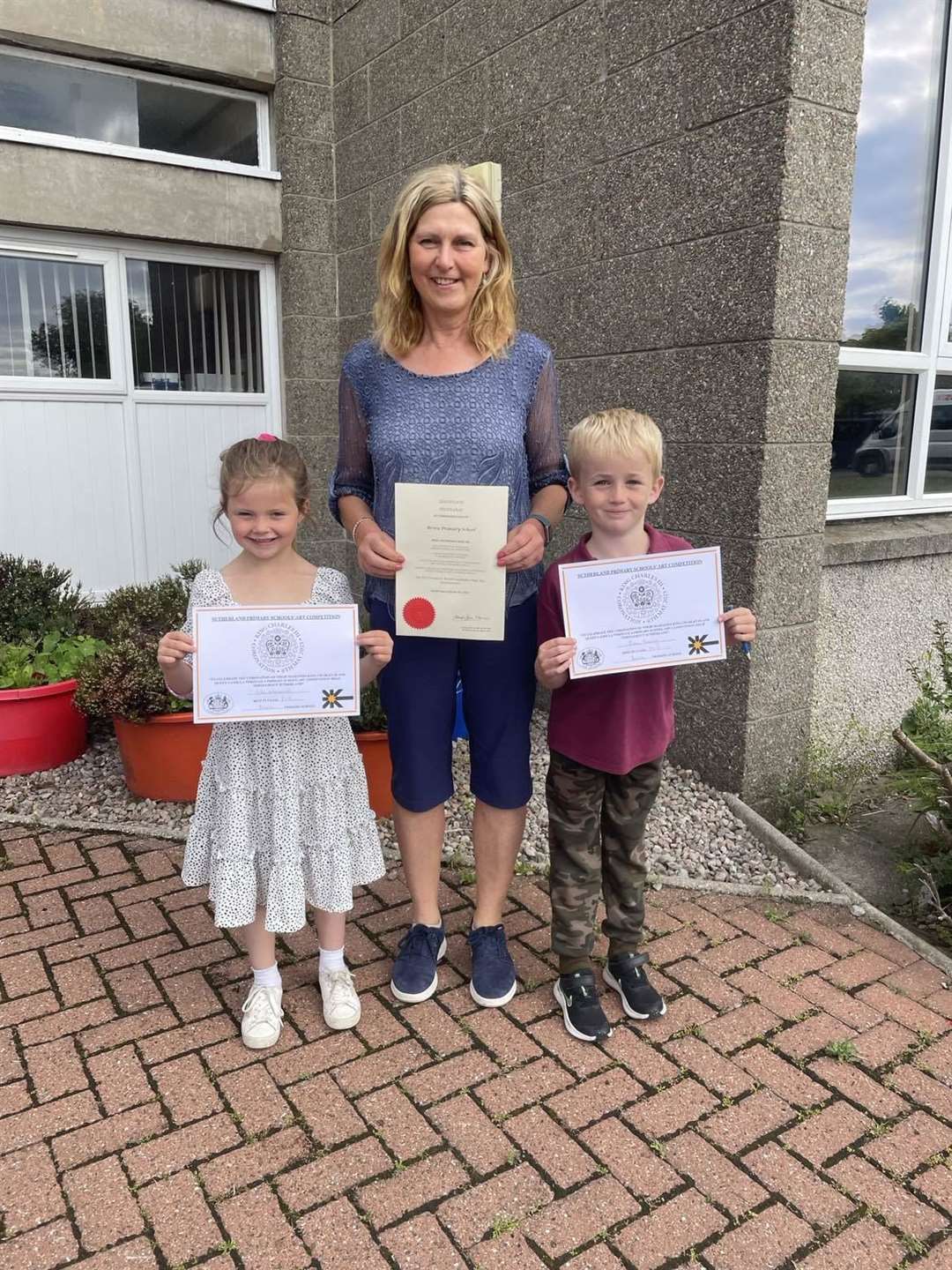 Deputy Lieutenant Dawn McKenzie returned to Brora Primary School, where she was head teacher until retirement last year, to present the coronation art competition certificates. With Dawn are Isla MacNicol, the p1-3 winner, and Evan Roney took first place in the p4-7 class. First in the nursery category was Ailsa Marie.