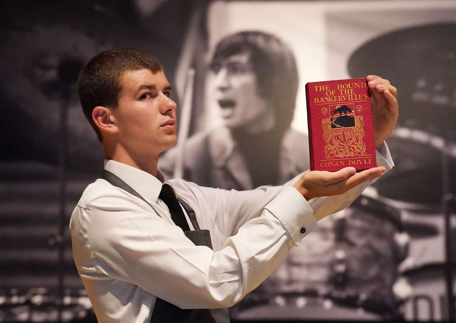 A Christie’s art handler holds a first edition of Arthur Conan Doyle’s The Hound of the Baskervilles (Jonathan Brady/PA)