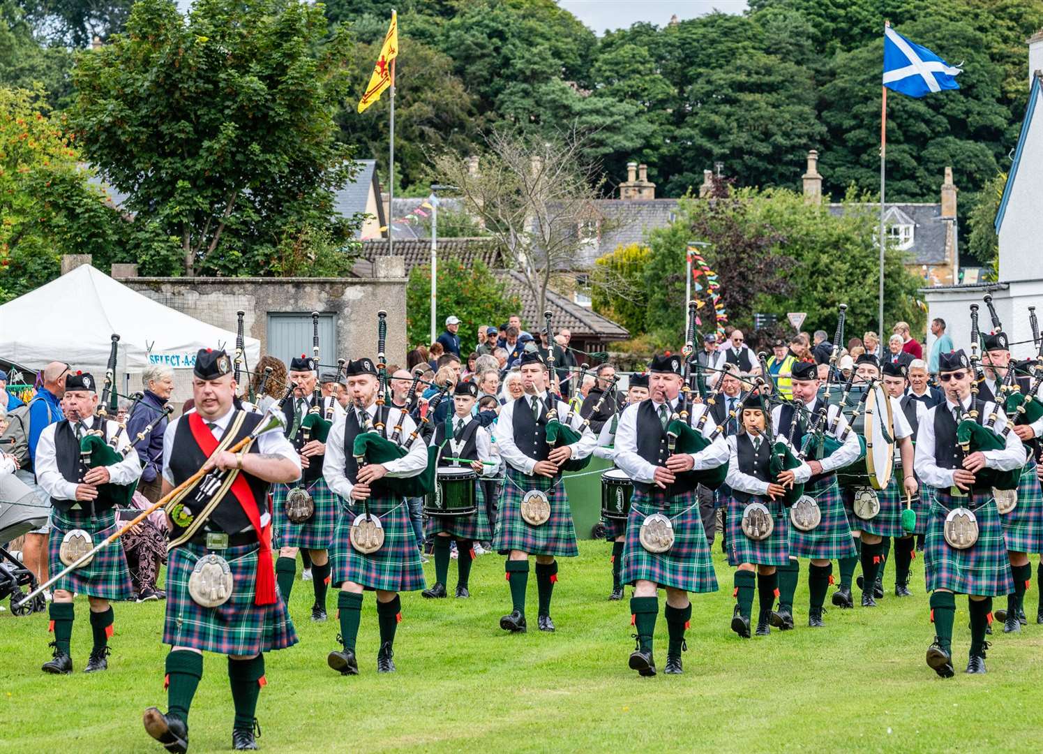 Drum Major Brian Fraser leads Dornoch Pipe Band into Meadow's Park with the Chieftain's Parade. Picture: Andy Kirby