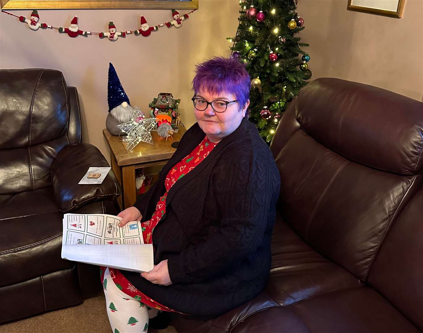 Scourie News editor Aileen MacDonald reading a copy of the festive greetings newsletter.
