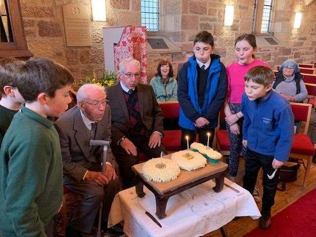 Eric Dawson, who turned 100 this week, was given a bit of help to blow out the candles on his birthday cake by local children and his son Barry.