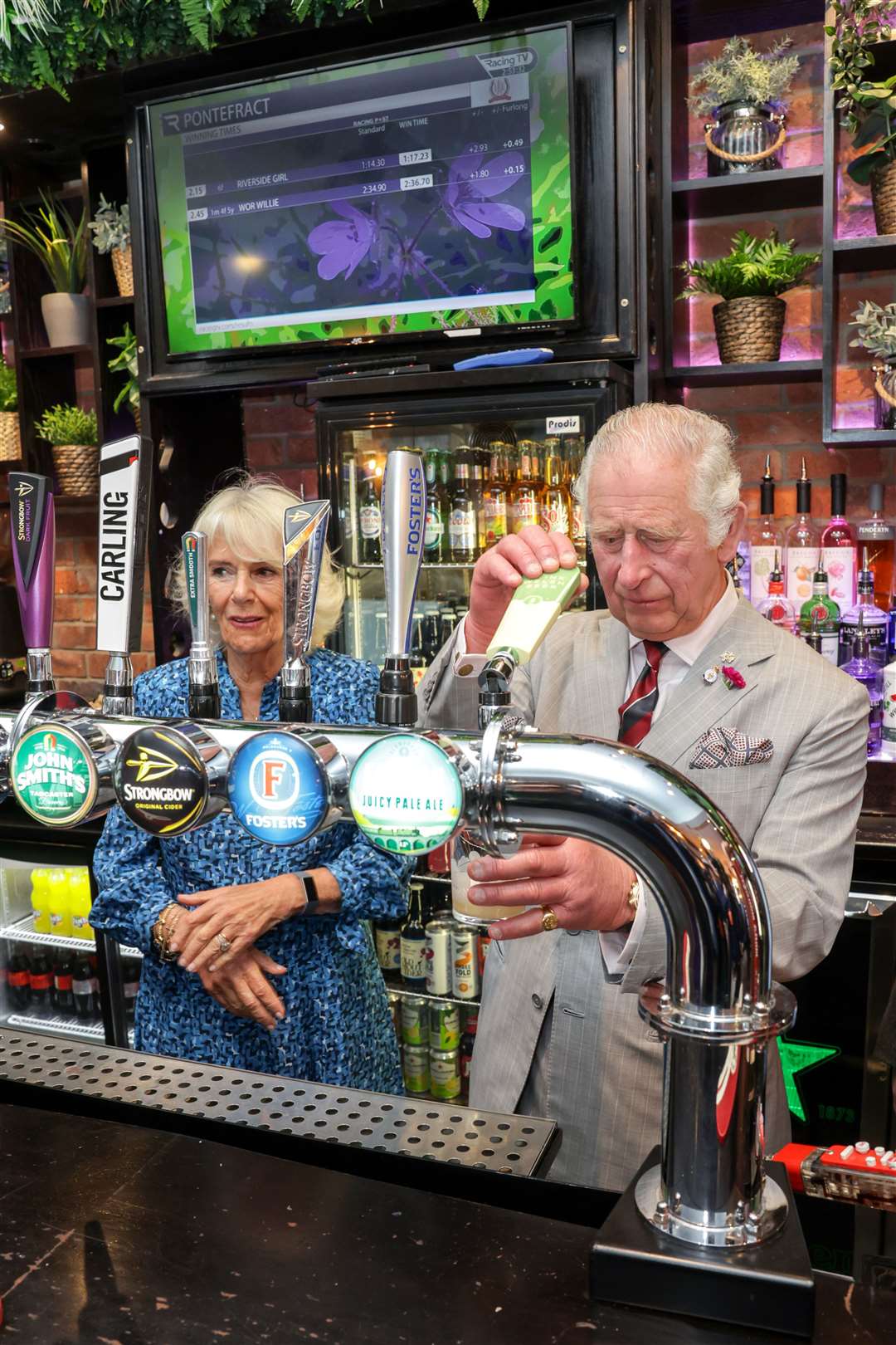 The then-Prince of Wales and the Duchess of Cornwall behind the bar at The Lion pub during a visit to Treorchy in July (Chris Jackson/PA)