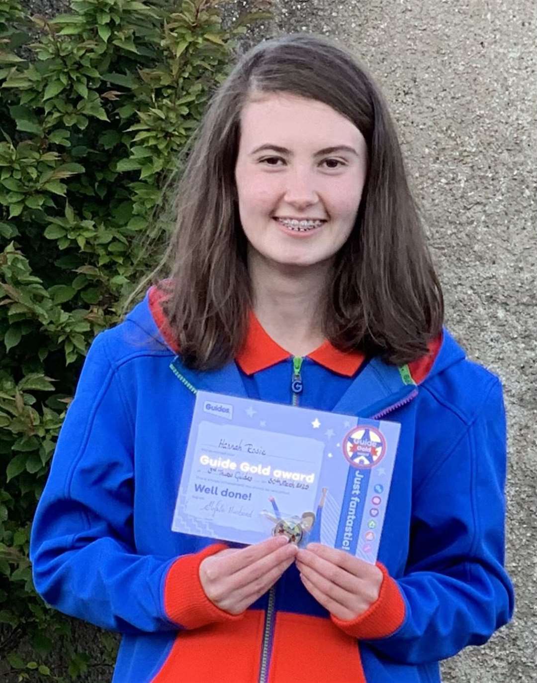 Hannah Rosie with her Gold Award certificate and badge.