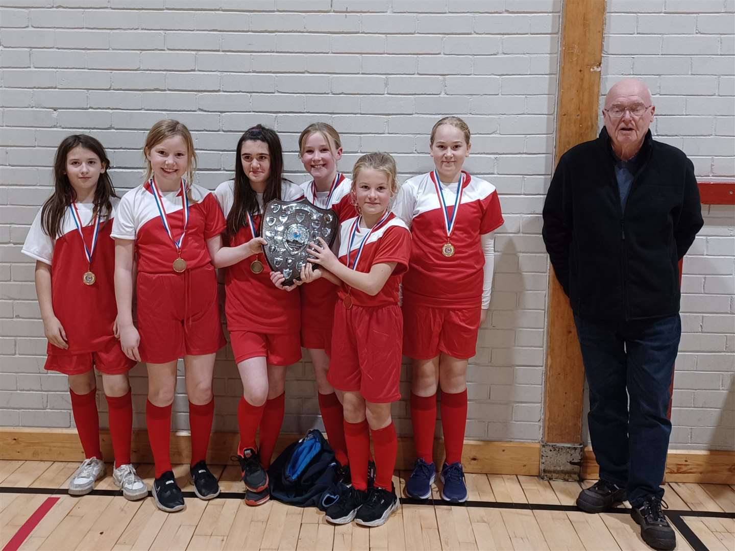 The girls' team from Brora with the handsome shield they won after coming first in the Big School category.