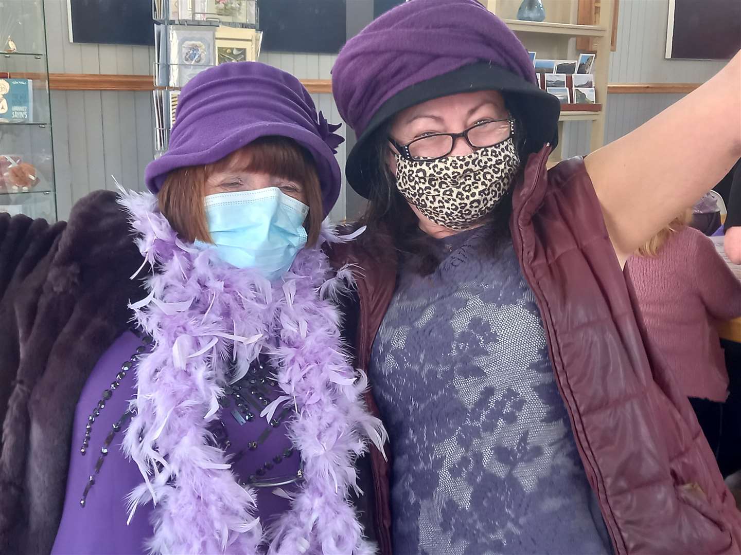 Wendy Simmonds and Theresa Cowie dressed in style with a feather boa and animal print face mask.