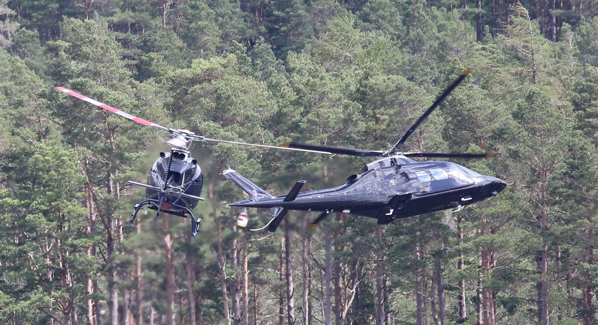 Helicopters filming scenes last year for the new James Bond movie in the Highlands.The helicopter on the left is filming the one on the right....pic Peter Jolly