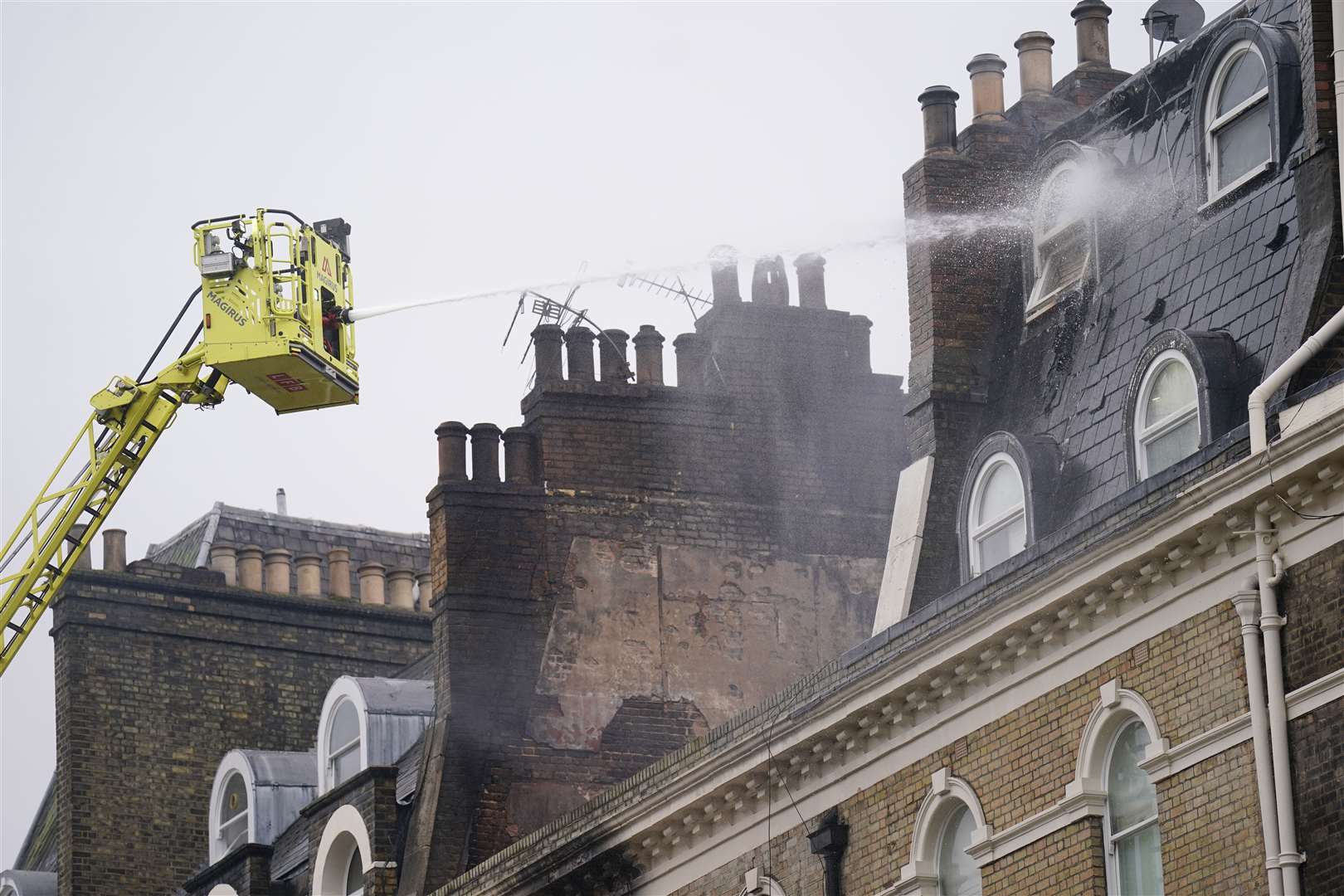 Firefighters dealing with the aftermath of the blaze that left 13 people suffering from smoke inhalation (James Manning/PA)