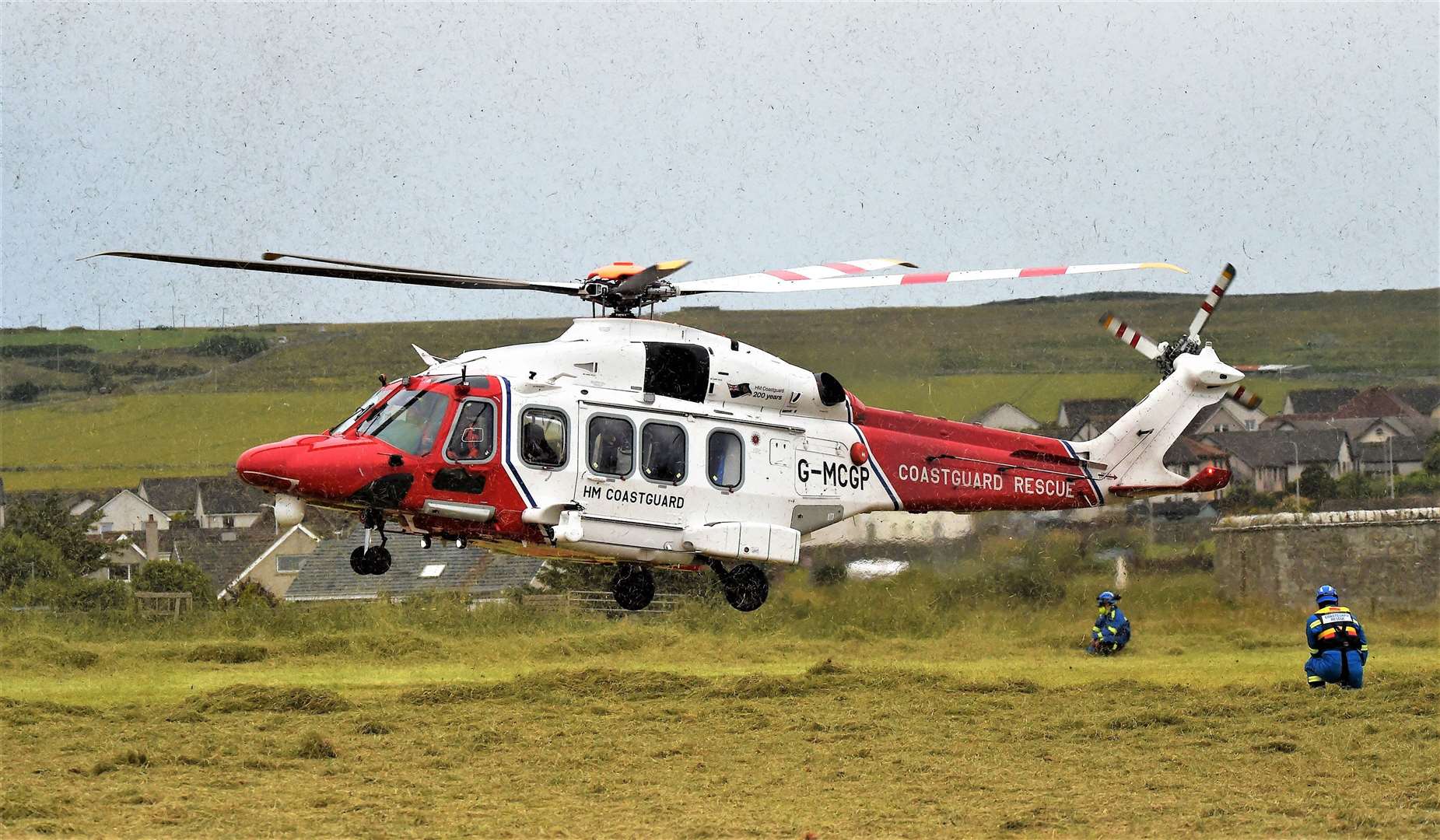 Newly cut grass flies in the air as the Coastguard helicopter lands near Victoria Walk. Picture: Mel Roger