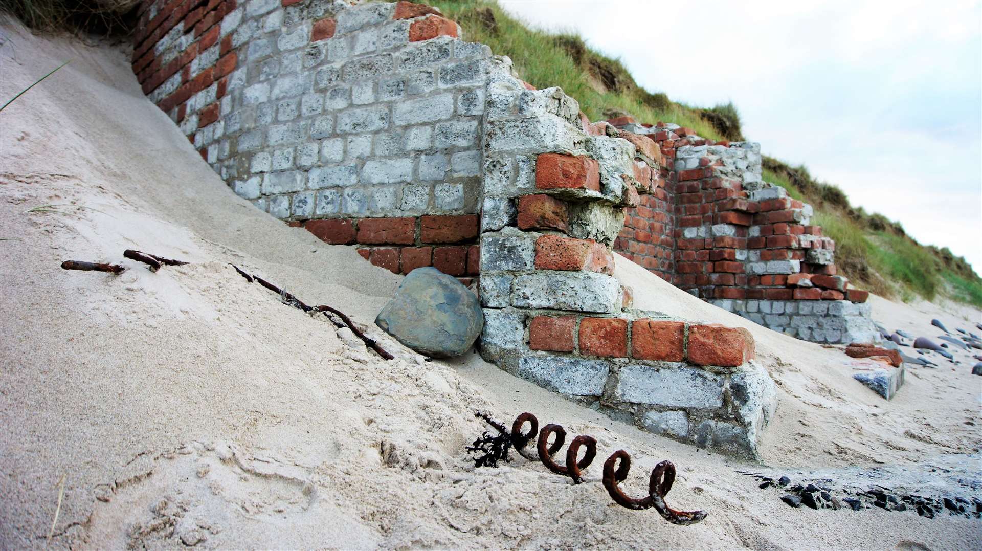 The remains of a pillbox and a corkscrew picket used for mounting barbed wire on Reiss beach – remnants of the global conflict 80 years ago. Picture: DGS
