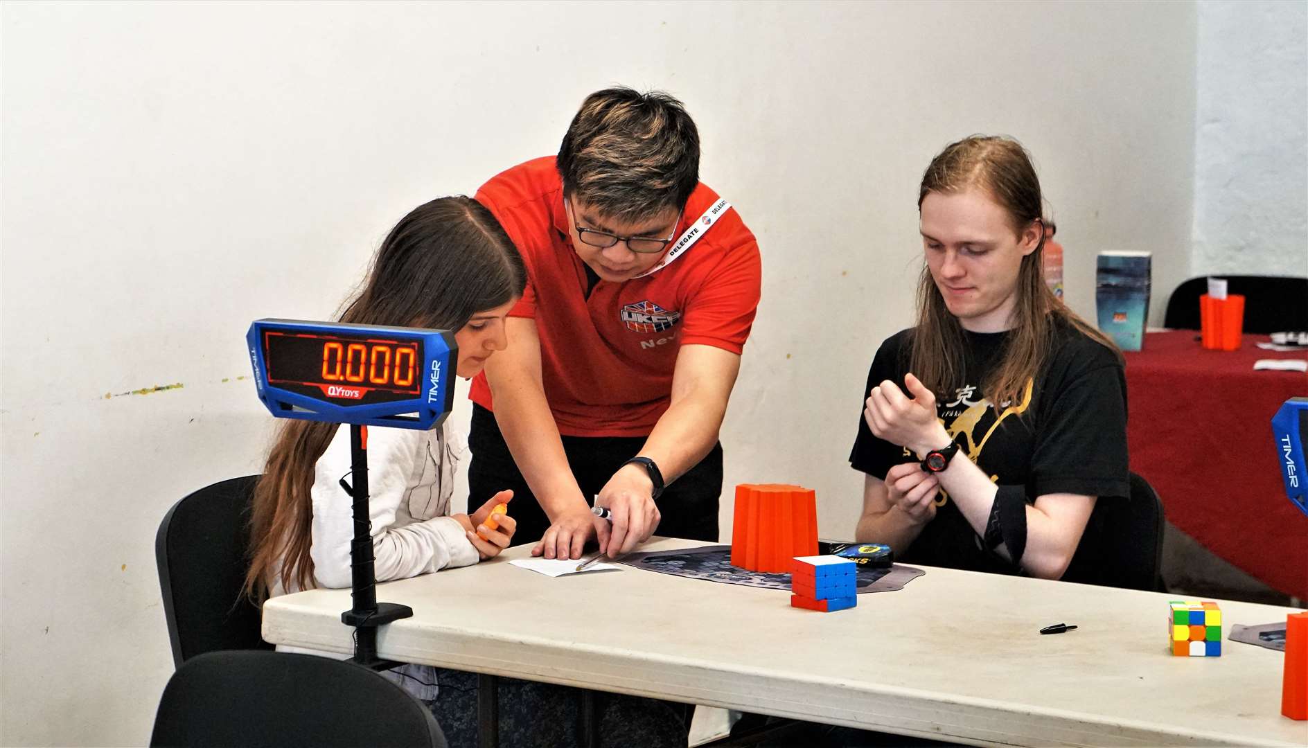 Nevins Chan, in red shirt, helps as the competition gets underway with electronic timers showing results. Picture: DGS