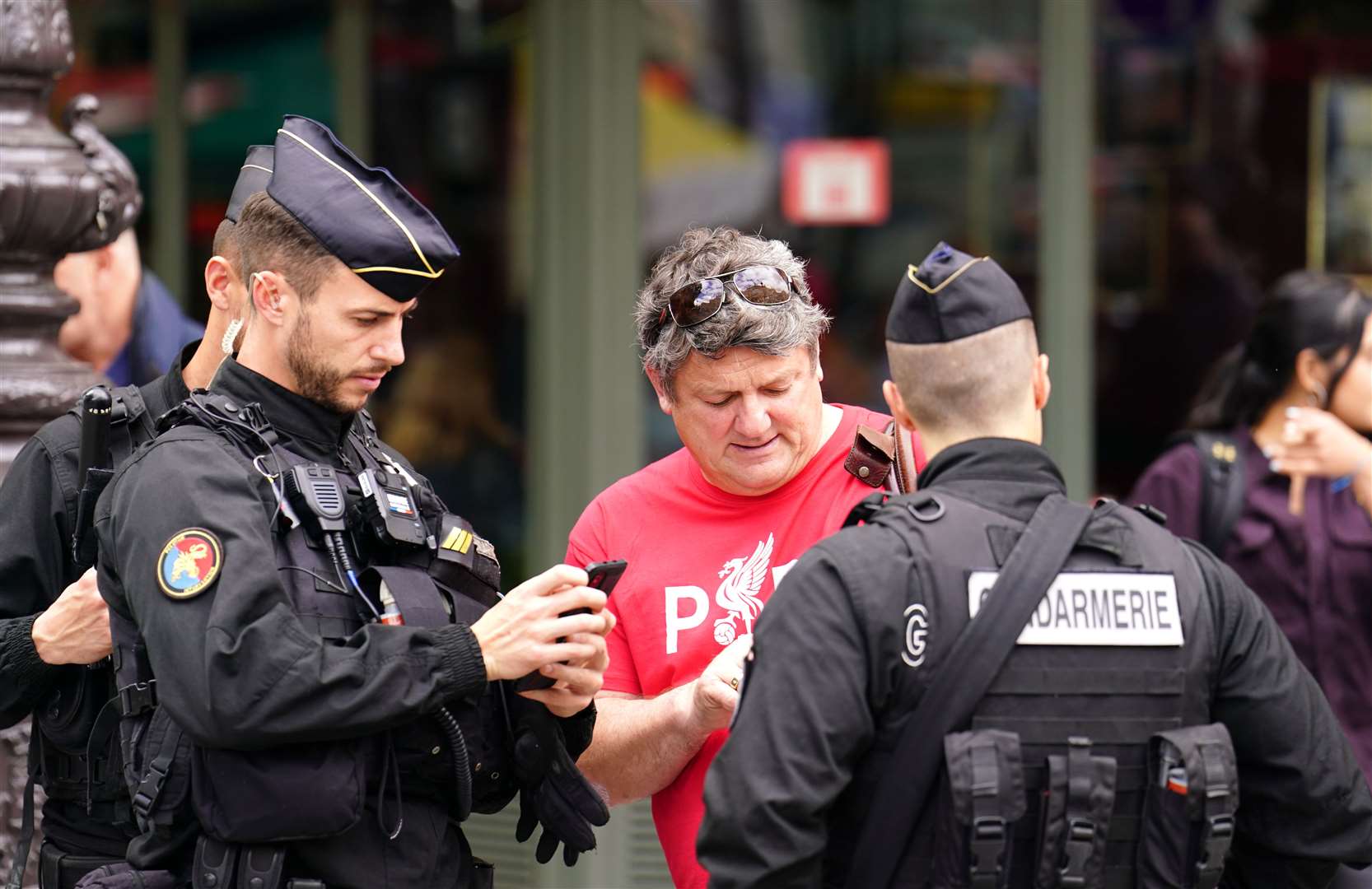 A Liverpool fan receives help from local police in Paris (Adam Davy/PA)