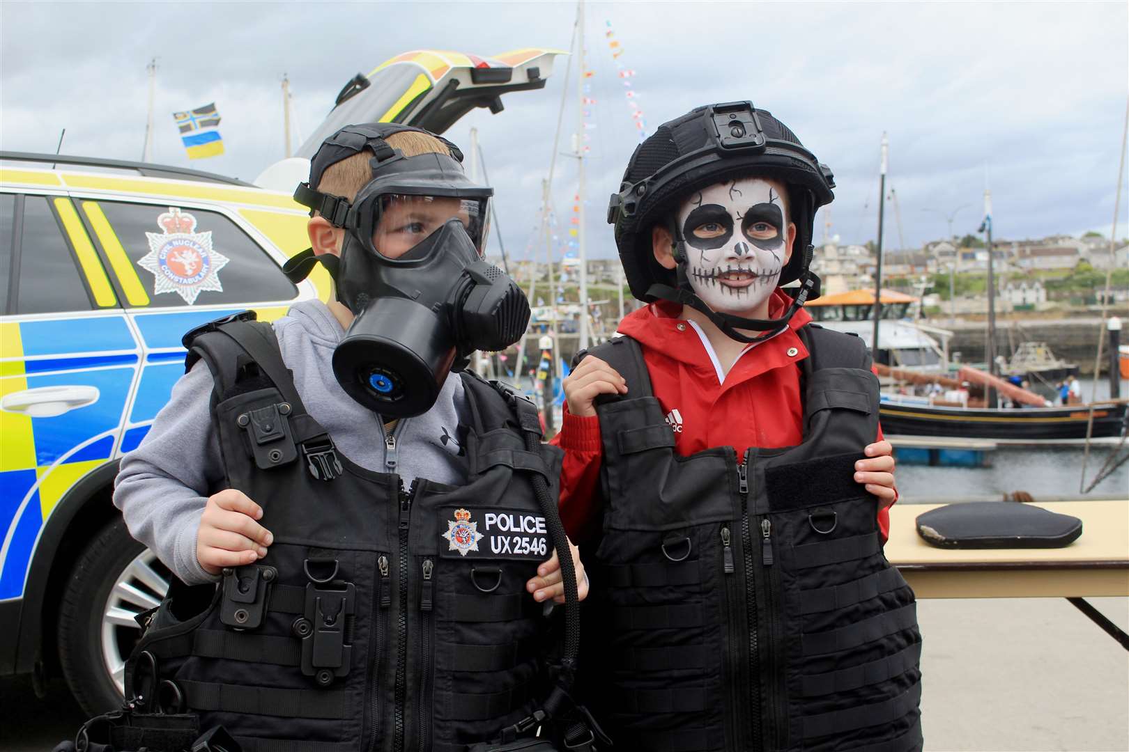 Seven-year-old cousins Noah Miller (left) and Joey Mackay at the Civil Nuclear Constabulary stand during Wick RNLI Harbour Day. Picture: Alan Hendry