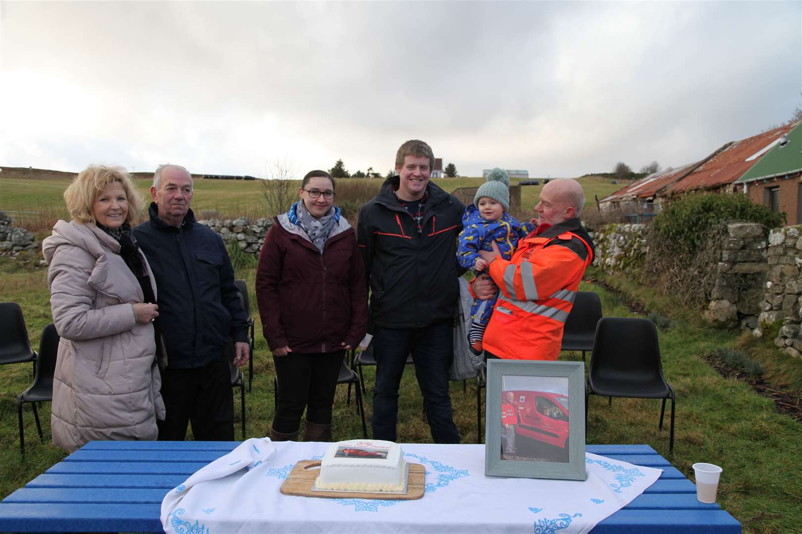 Billy Mackay, above, with his grandson Callum, stands next to his son Murdo Mackay, and Murdo’s partner Laura Gunn. Rosemary Cameron, far left, helped organise the community event, and James Horne, second left, the former postmaster at West End Stores, presented Mr Mackay with the community collection.