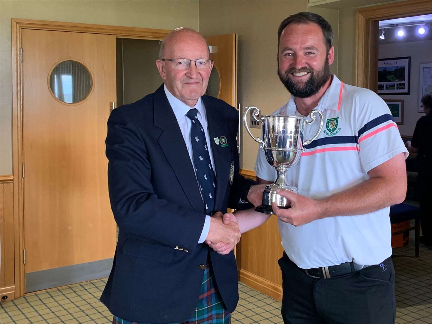 Royal Dornoch club champion Alexander MacDonald (right) receives the trophy from men’s captain Willie MacKay