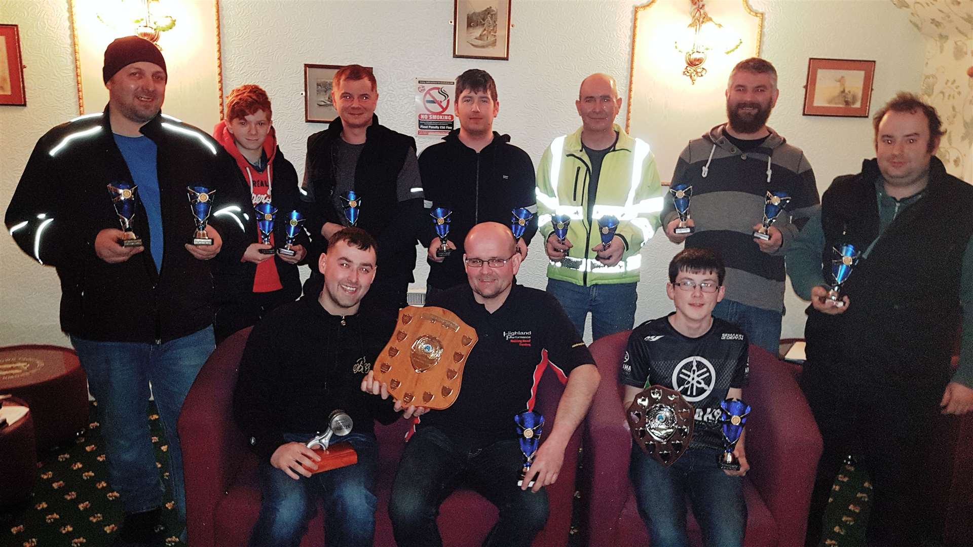 Peter Campbell (front centre) receives the championship shield from outgoing 2019 chairman Craig Manson at the Caithness Autocross Club’s AGM held in Watten – with son Kian Campbell, junior champion, alongside as other club members look on.