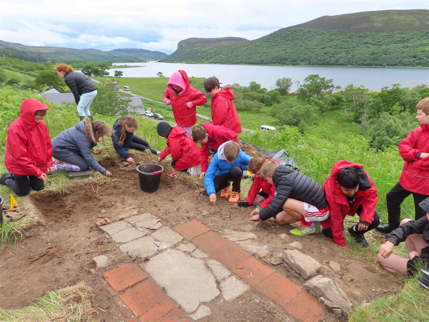 Senior classes from Brora primary school visited the dig and were put to work. Here they are digging close to the stunning red clay tiles at the doorway.