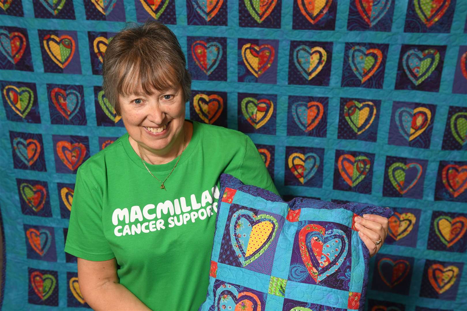 Shona Docherty, Macmillan Cancer Support Easter Ross fundraising committee chair showing off the cushions and the quilt inspired by Gill Thompson. Picture: James Mackenzie.