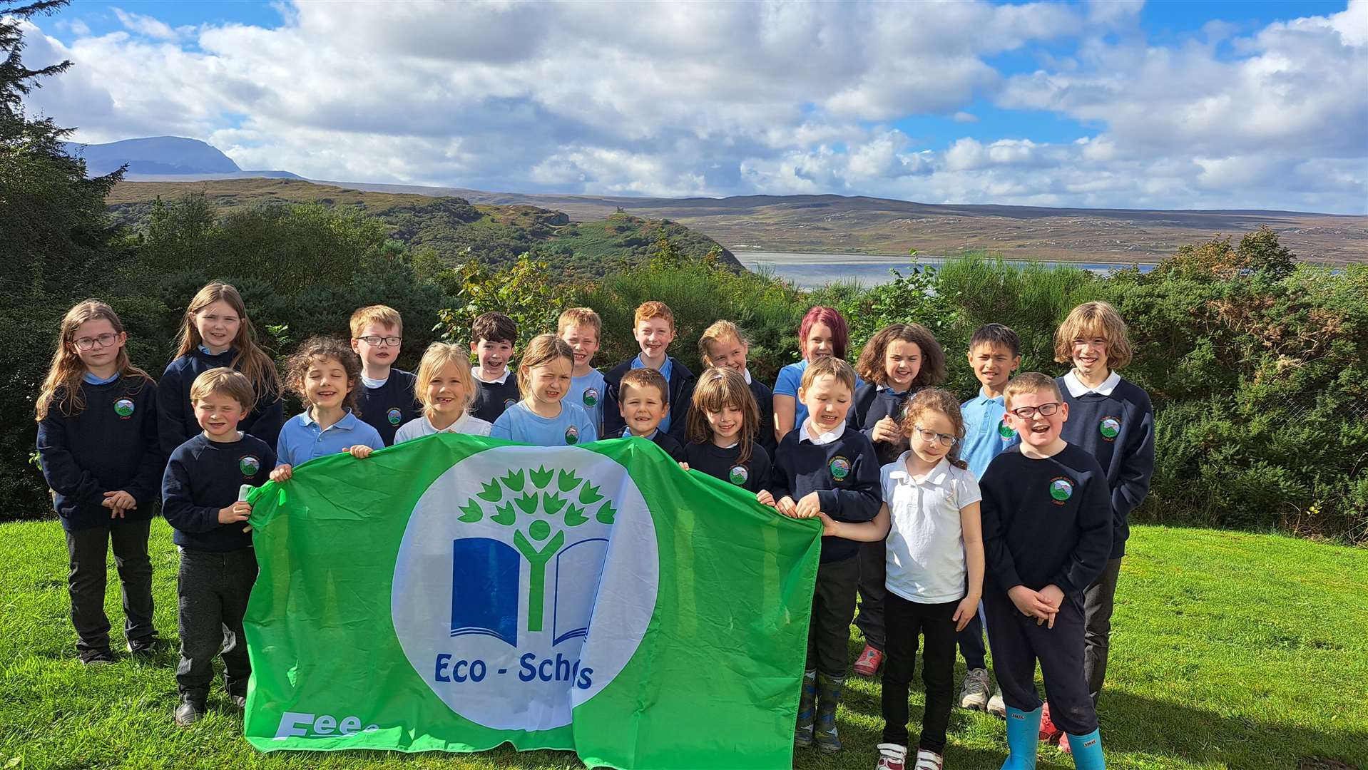 Tongue Primary School pupils proudly show off their Eco-Schools green flag. The green flag is an annual accreditation and needs to be renewed each academic year.