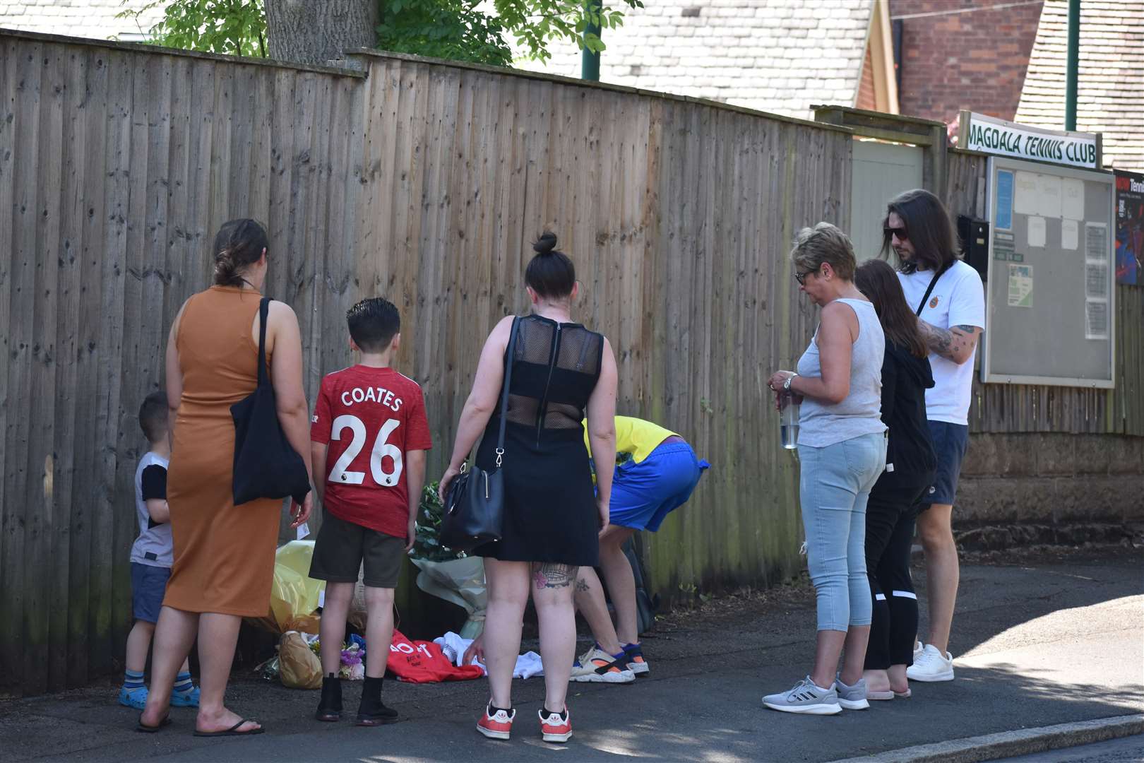Lee (yellow top centre) and James Coates (white top right) the sons of Ian Coates, visit the scene with other family members (Matthew Cooper/PA)