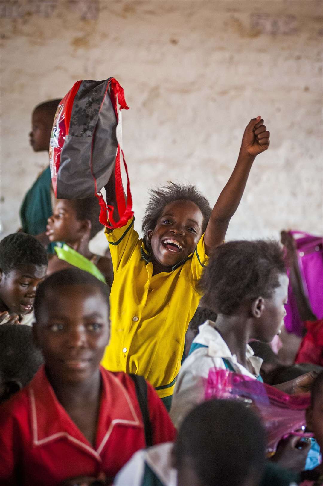 A child at a school in Malawi holding a bag from the Mary’s Meals Backpack Project.