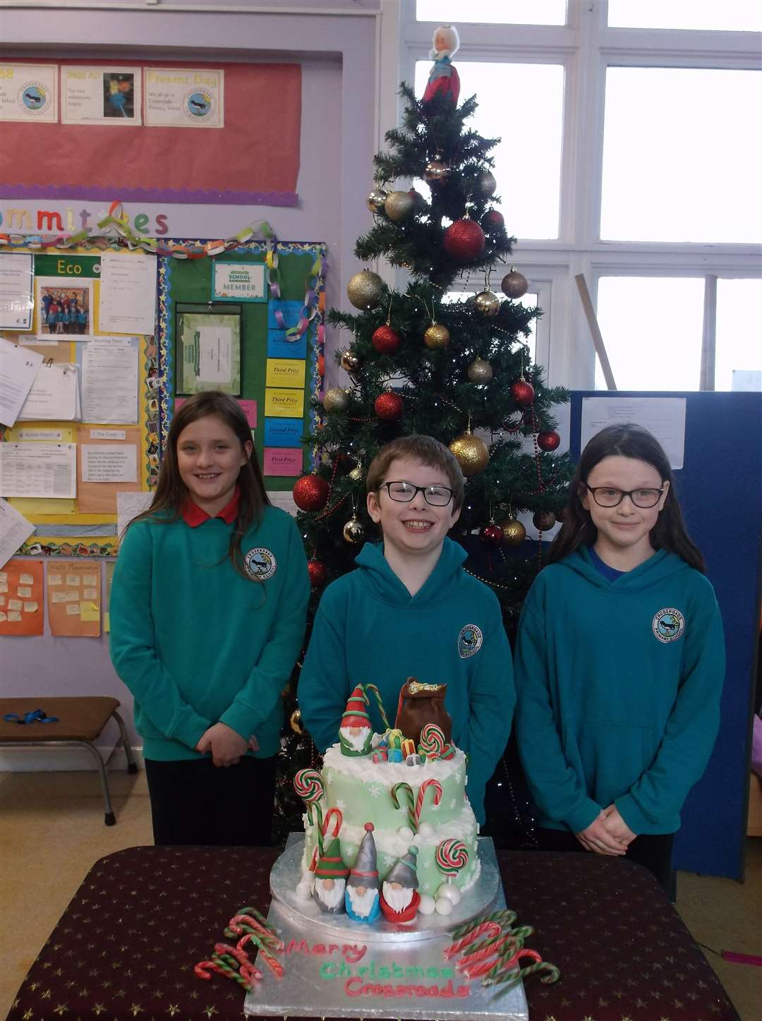 Primary 6 pupils Lana Myatt, Dylan Macdonald and Moira Darby with the royal Christmas cake which was delivered from King Charles.