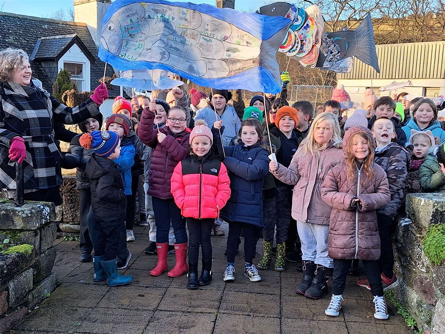 Pupils from Helmsdale Primary School marched behind the pipe band, waving banners they had made with salmon on them.