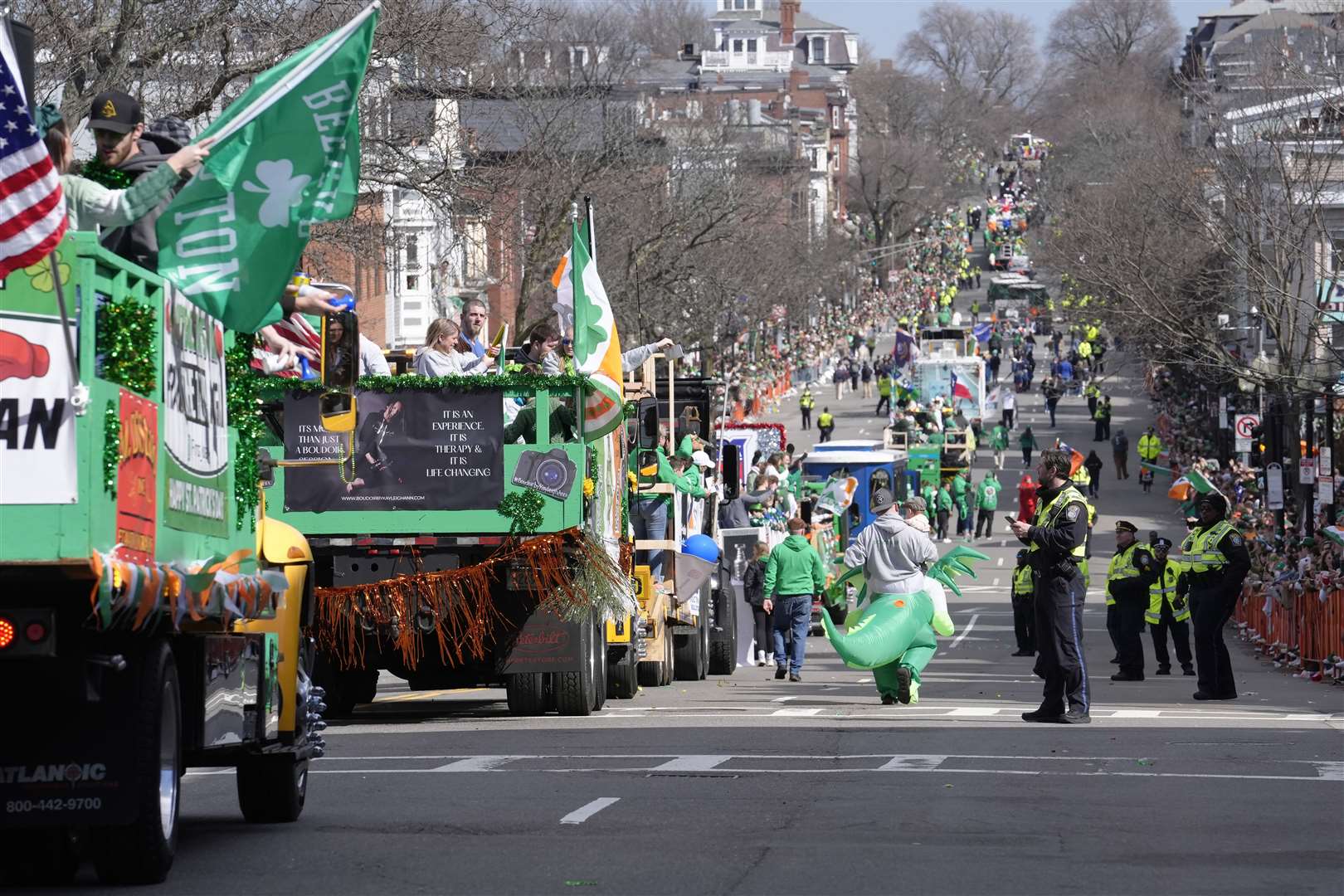 Floats and vehicles make their way along the parade route as spectators watch the St Patrick’s Day parade in Boston, US (Steven Senne/AP)