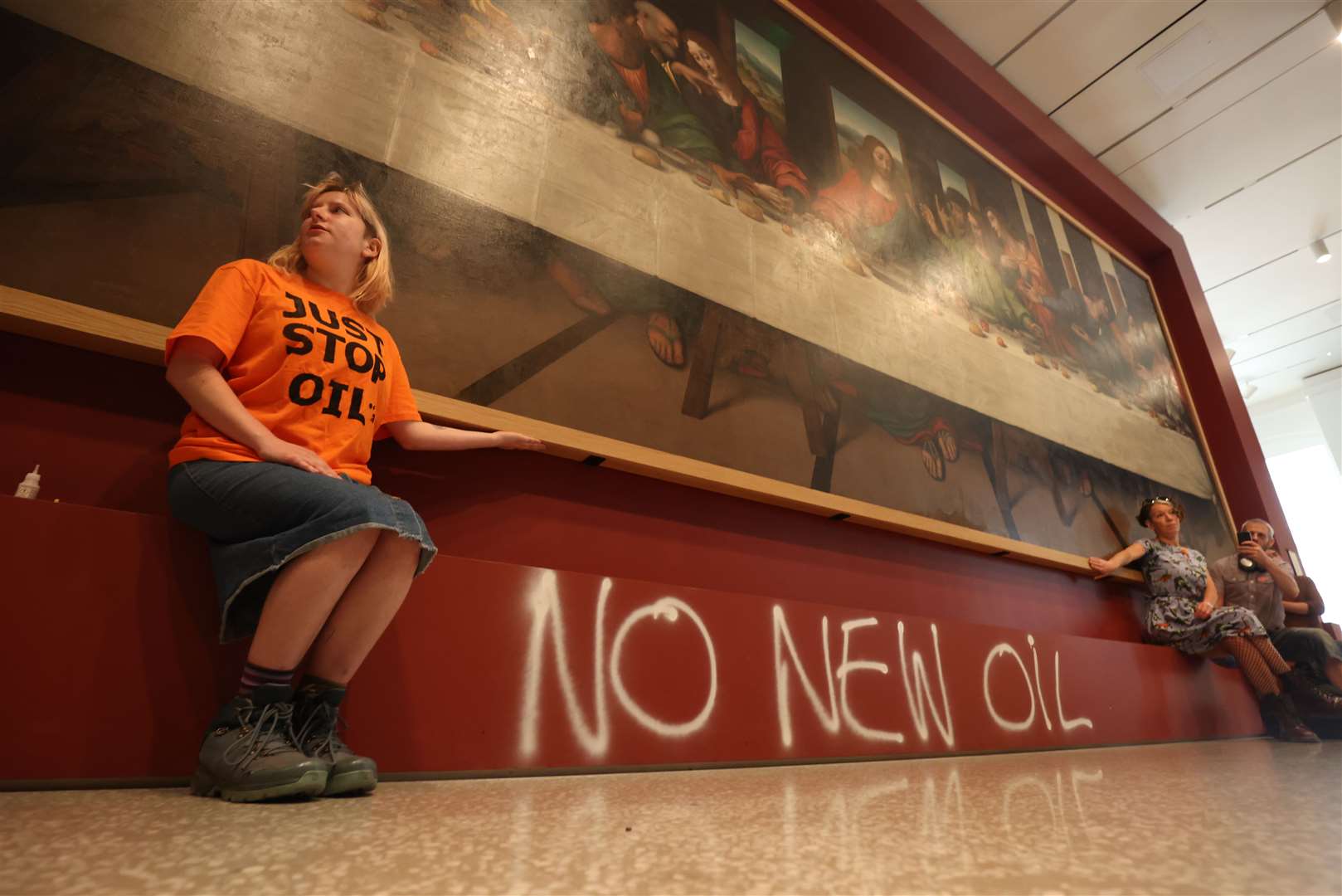 Protesters attached themselves to the frame while the words ‘No New Oil’ were spray-painted in white on to the red plinth (James Manning/PA)