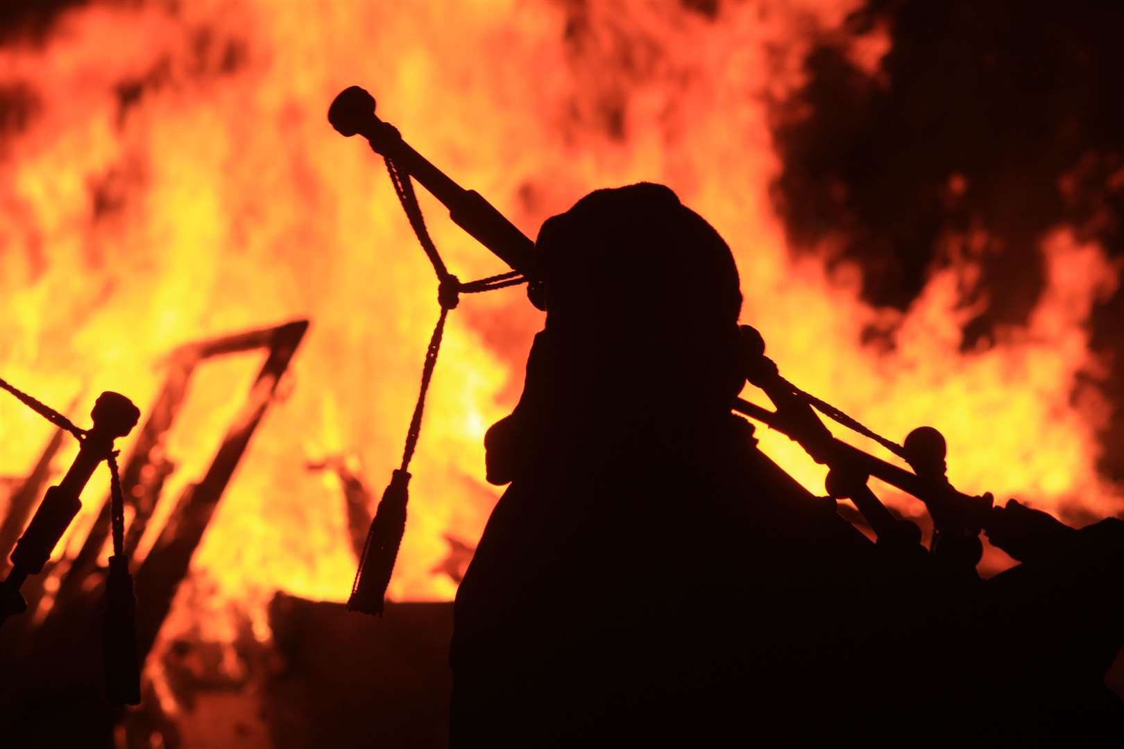 A piper silhouetted against the flames during last year's Hogmanay bonfire at the Bignold Park. Picture: Alan Hendry