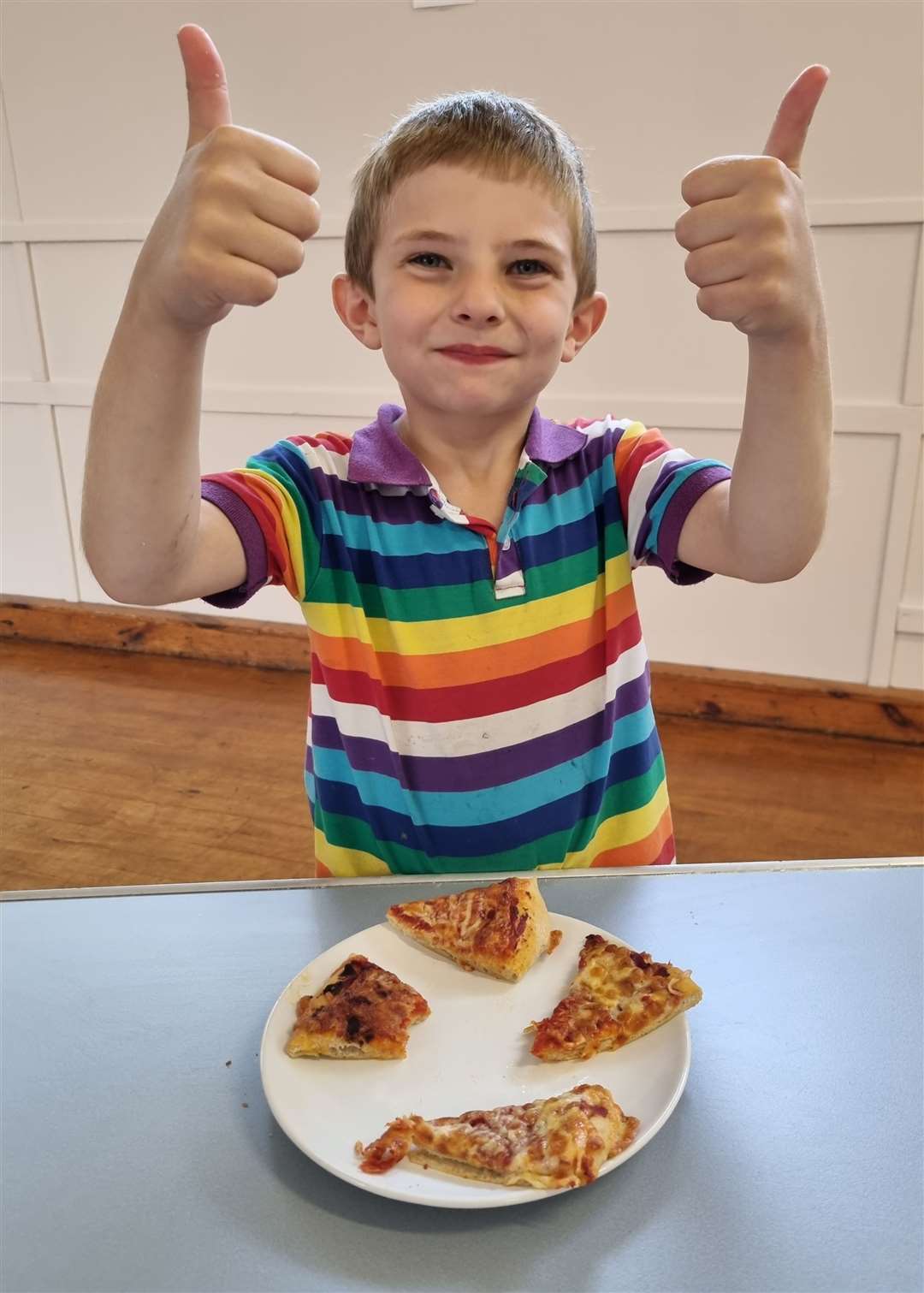 Adam Ross gives a thumbs-up to the delicious pizza he made.