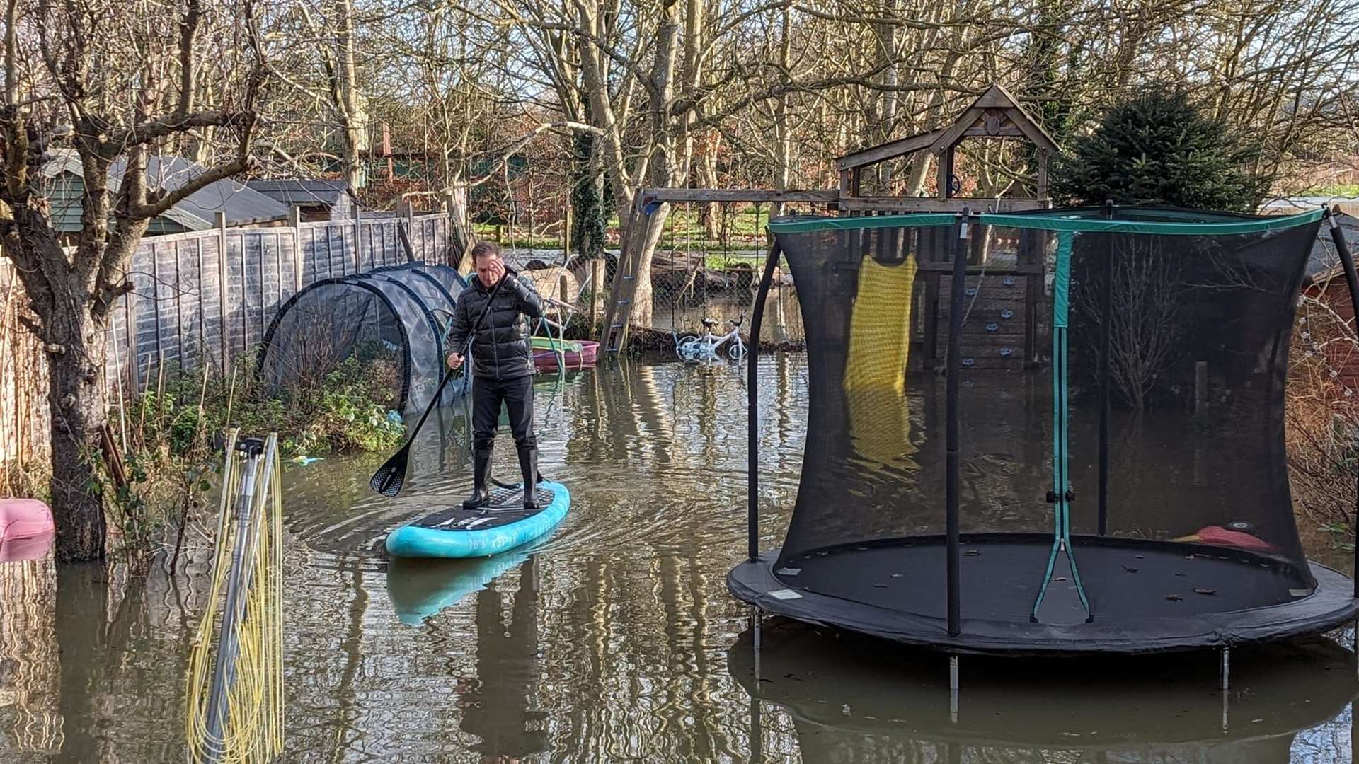 Michael Kneafsey had to use a paddleboard to get around his garden (Vanisha Kneafsey/PA)