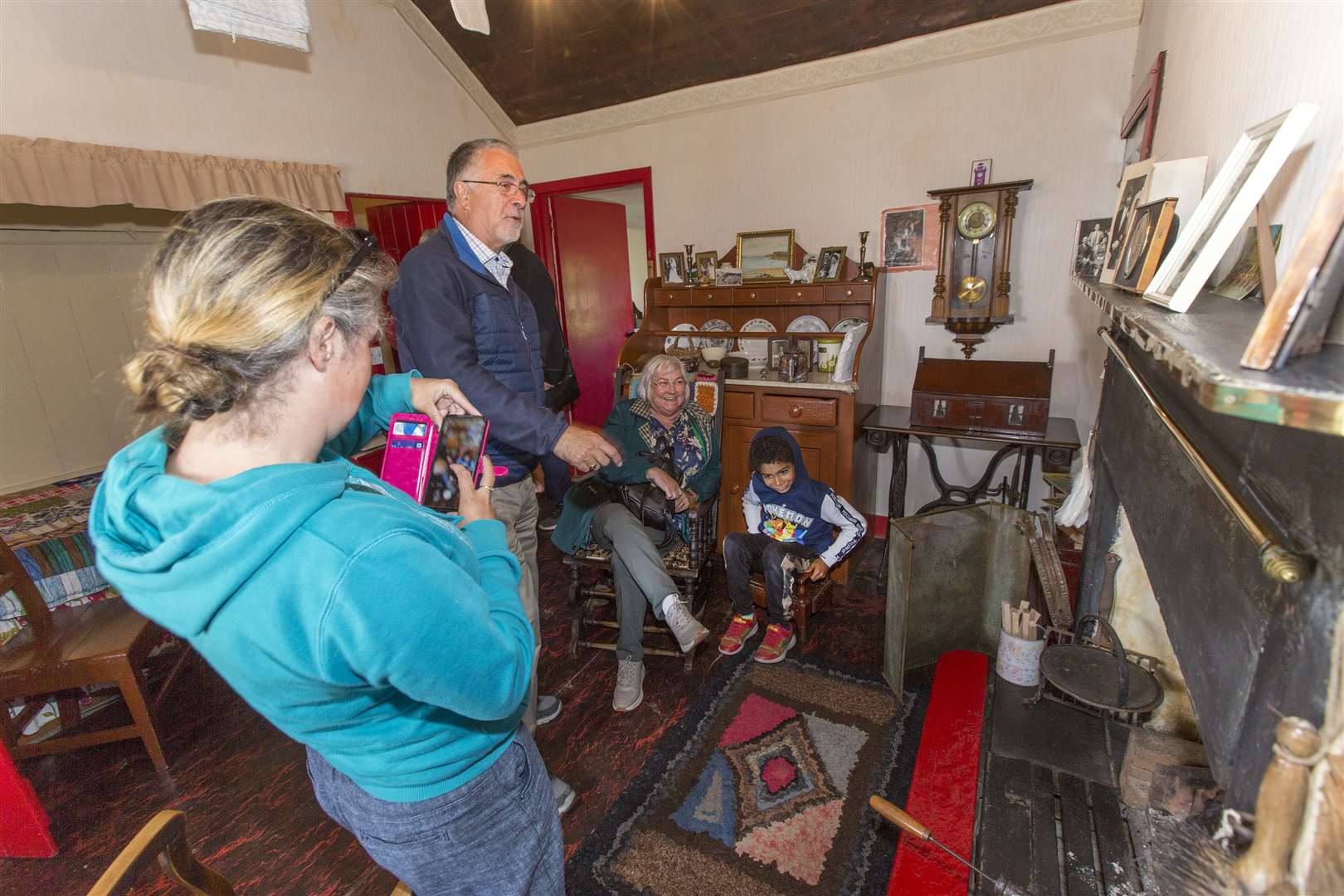 Mary Ann's granddaughter Anne Fitzsimmons and great-great-grandson Charlie Fitzsimmons (both seated) pose for a photo in the cottage's living room, taken by great-granddaughter Claire Fitzsimmons, while her dad Jim looks on. Picture: Robert MacDonald / Northern Studios