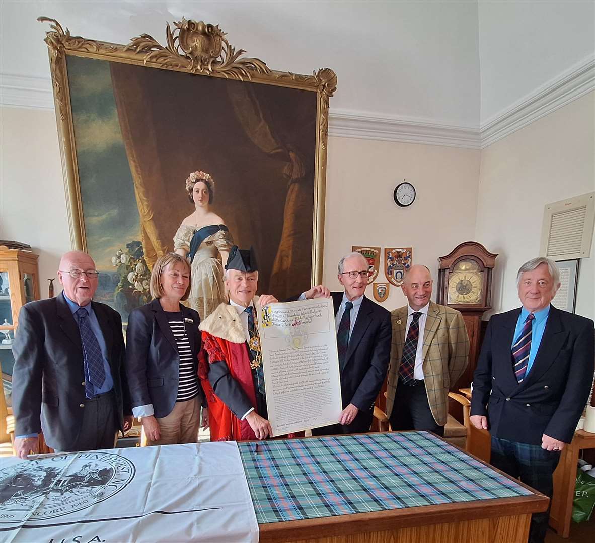Provost Murray and Mayor Strickland hold up the agreement. From left, Cllr Jim McGillivray; Alison Davies, Dornoch Heritage SCIO trustee; Neil Hampton, general manager of Royal Dornoch Golf Course; and Dornoch Area Community Council member Jimmy Melville. The ceremony took place in the council chamber at Dornoch.