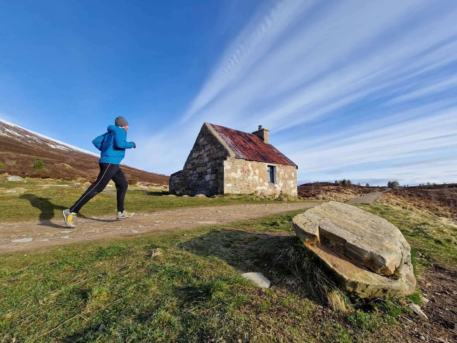 John strides past Ryvoan bothy on a run in the Cairngorms National Park.