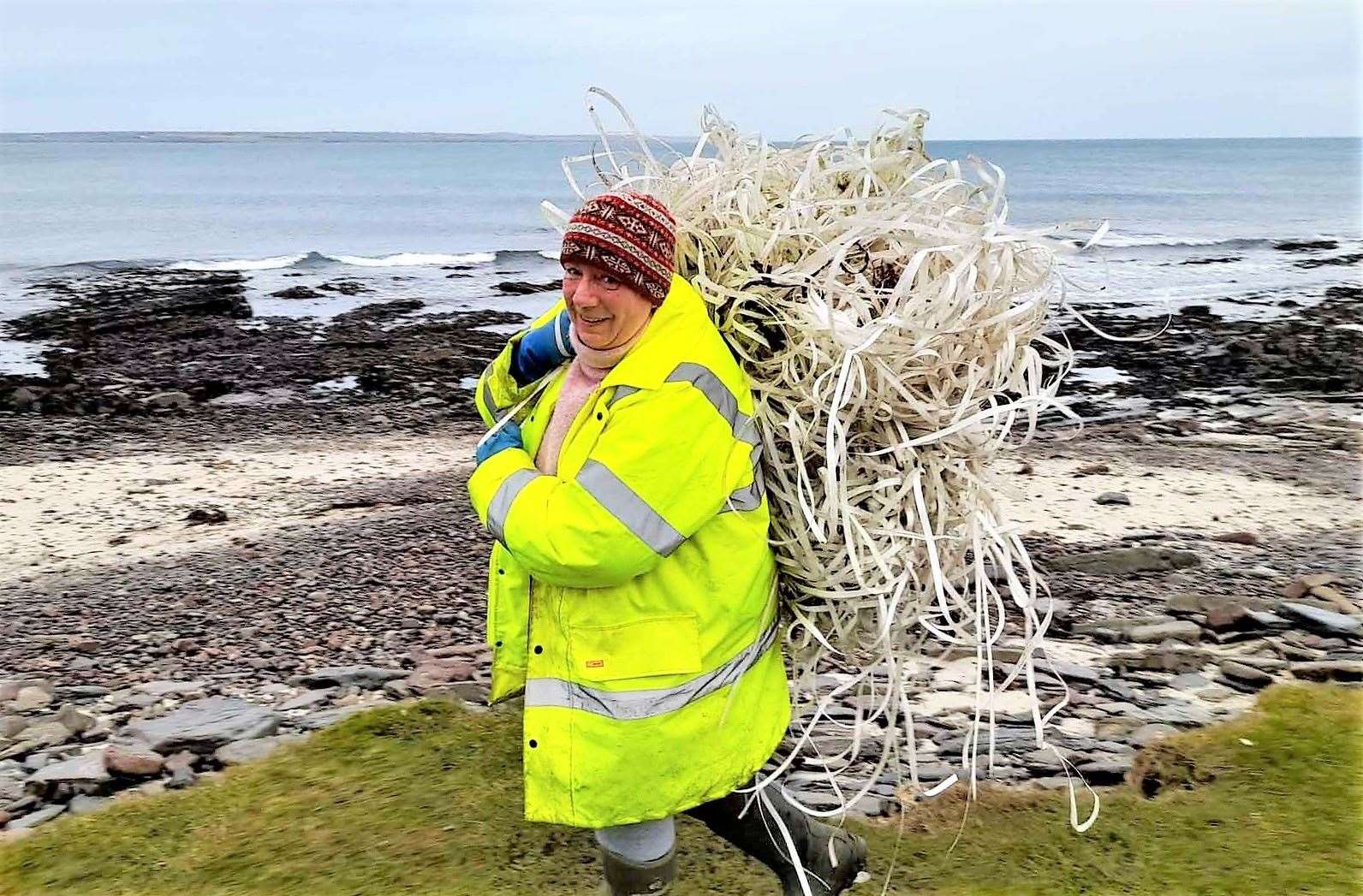 Caithness Beach Cleans stalwart Dorcas Sinclair removes one of the bundles. Pictures: Isobel Grewcock