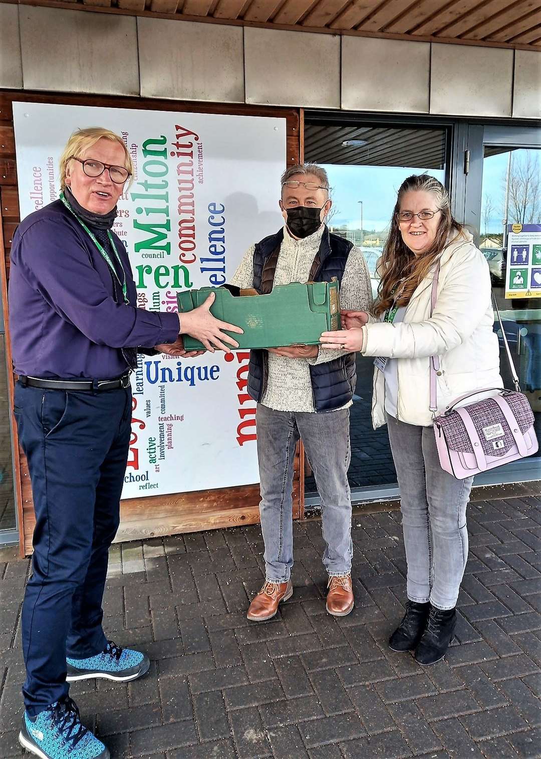 Dave and Liz Kerr from Budding Engineers handing a box of laptops to Robert Gill (right), headteacher of Milton of Leys Primary School in Inverness.