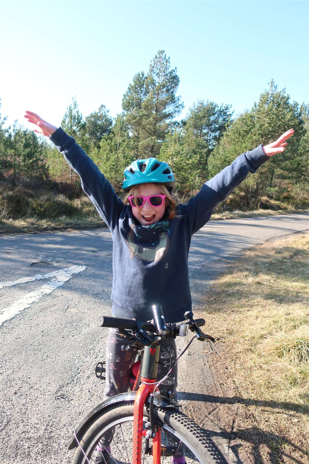 Jennifer celebrates reaching the top of the Macbain hill on a bike ride from Inverness.