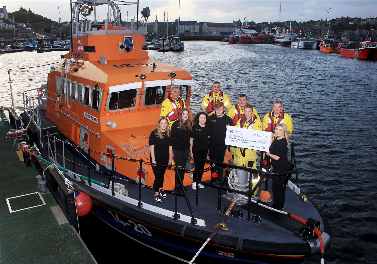 Emily Morrison (right) presenting the cheque for £2823 to coxswain Allan Lipp alongside other members of Wick Young Fiddlers and some of the lifeboat crew. Picture: Alan Hendry