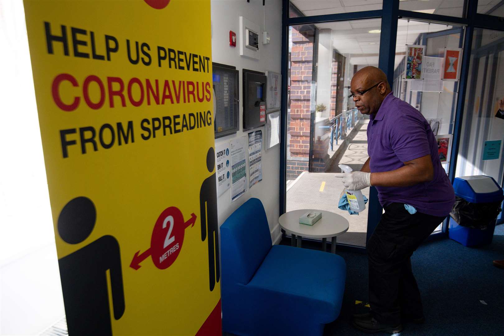 A cleaner disinfects the reception at the Jewellery Quarter Academy in Birmingham, ahead of reopening (Jacob King/PA)
