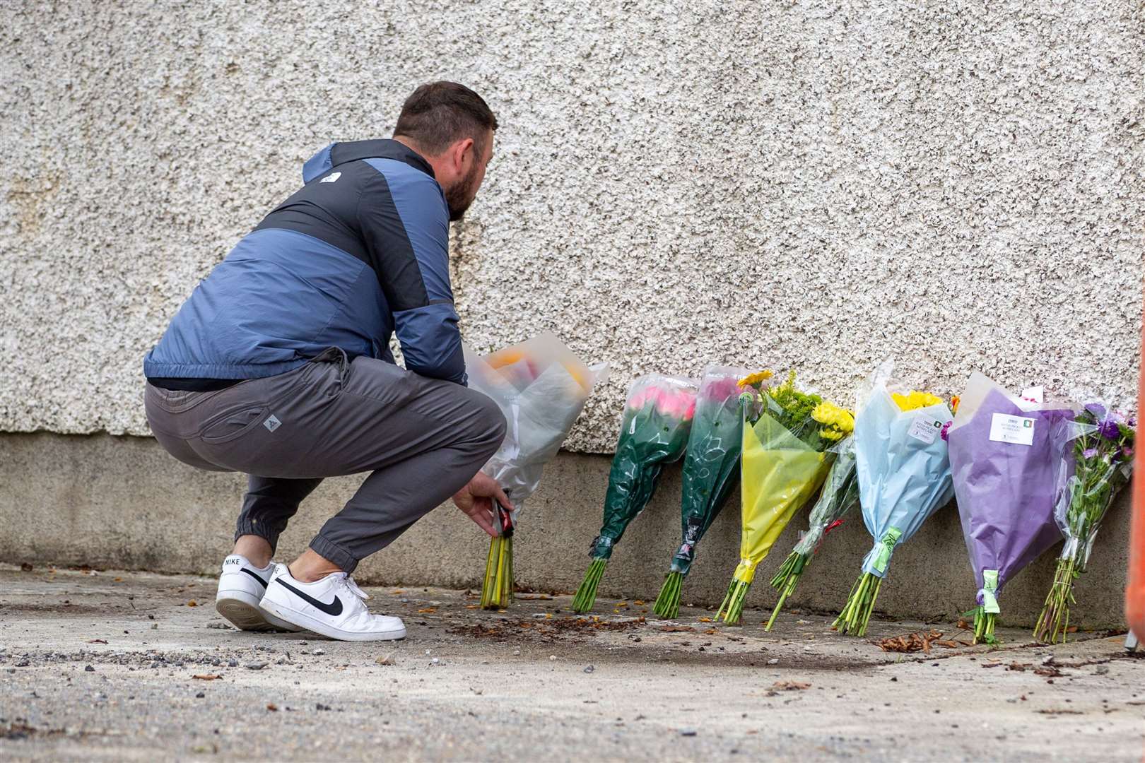 A man lays flowers near to the scene of the crash (Damien Storan/PA)
