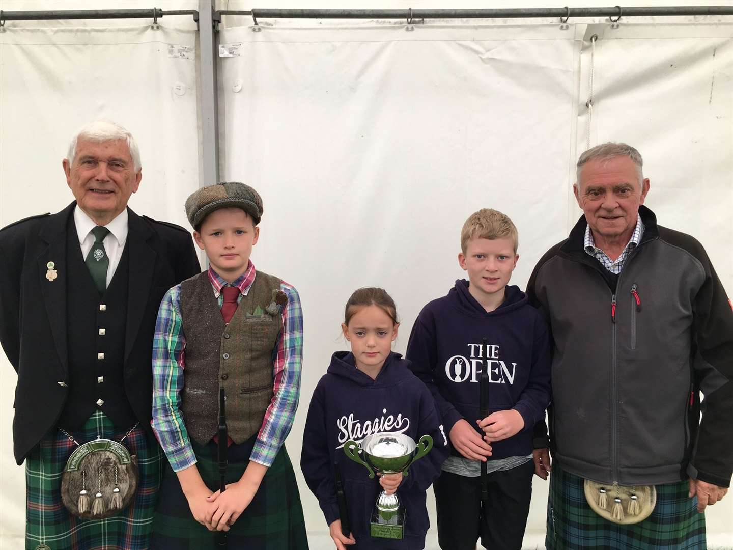 Young Ruby Stevenson, Invershin, won the primary school chanter competition. Flanking Ruby are Lyster Price-Davis (left) and Toby Dingwall who came second equal. Judge Charlie Ross stands far left and judge Graham Grant far right.