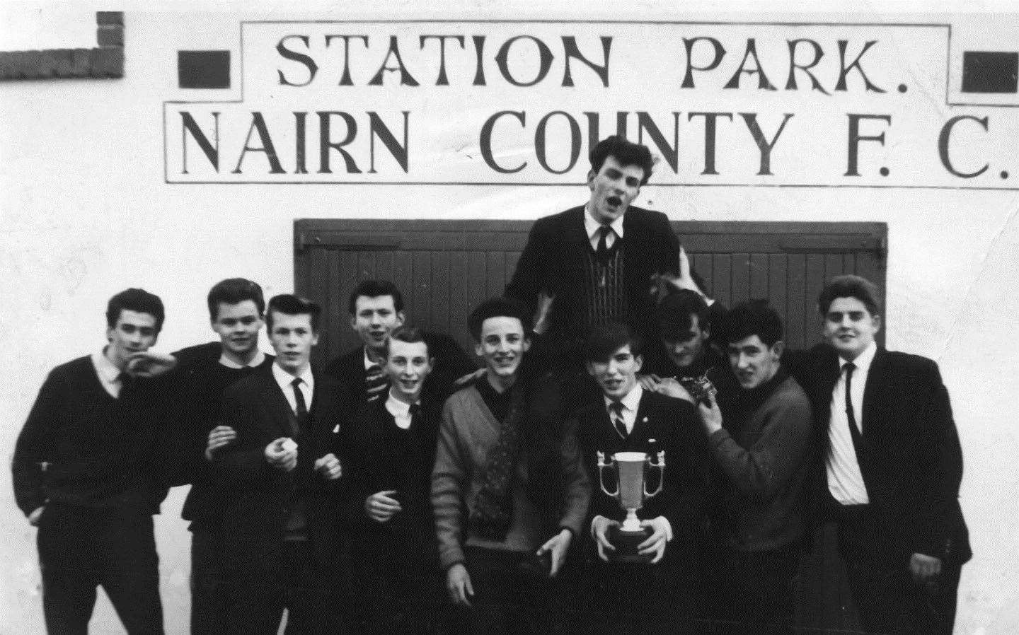 Golspie High School players celebrate outside Station Park, Nairn after winning the North of Scotland Cup. L to R: Bobby MacLeod, Arthur Fraser, Cecil Melville, Allan Lannon, Ian Taggart, John MacKay, Christopher Yuill, Alan Syme, John Robertson, Adam MacPherson with David Cowie being help shoulder high.