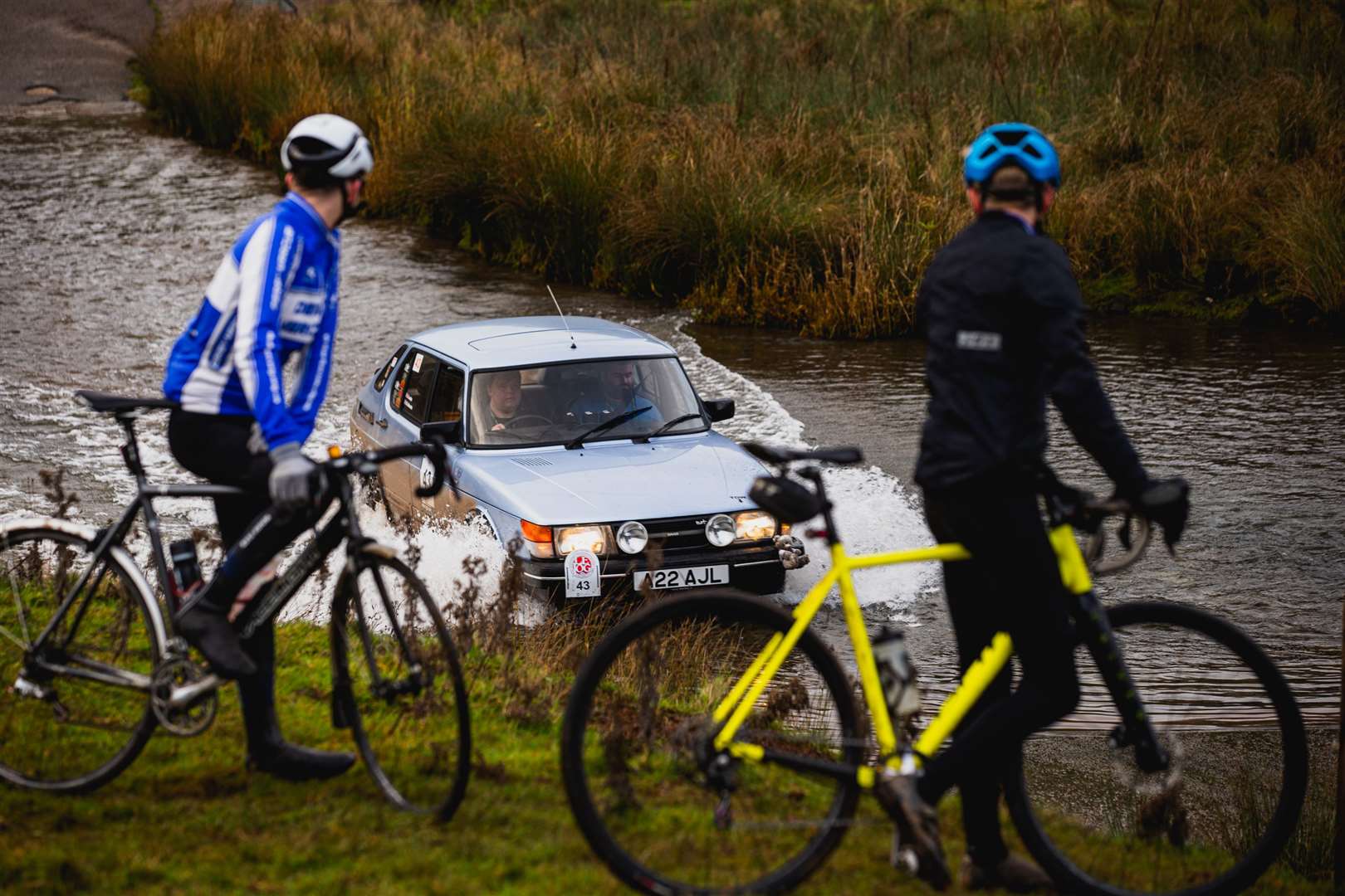 Cyclists watch in disbelief as competitors drive along the precarious route. Picture: Will Broadhead