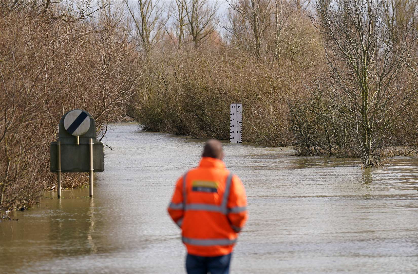 A local resident looks along the flooded A1101 in Welney, Norfolk (Joe Giddens/PA)