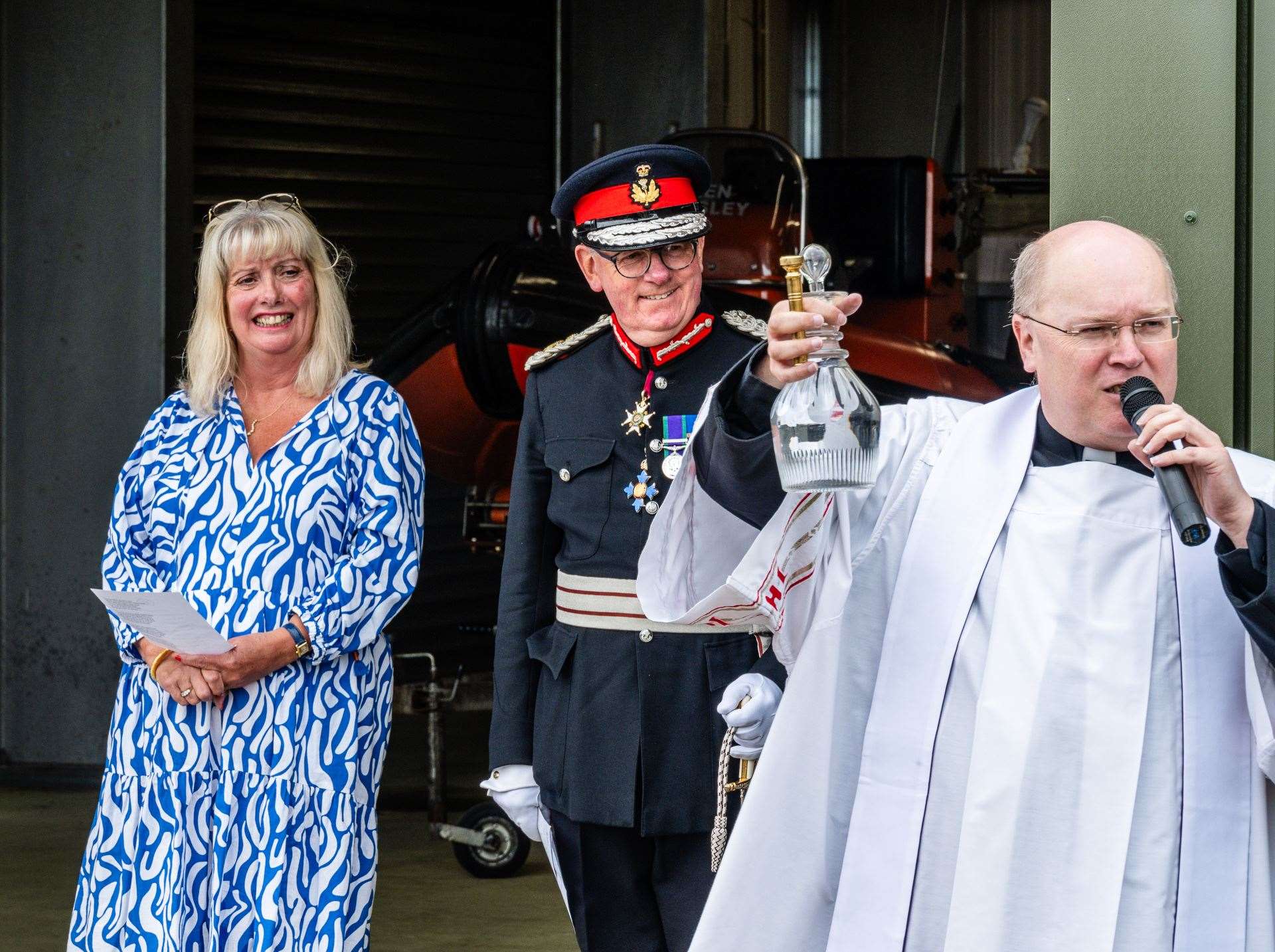 Father Simon Scott holds up the carafe of holy water. Next to him are Deputy Lord-Lieutenant Kim Tulloch and Lord-Lieutenant Patrick Marriott. Picture: Andy Kirby